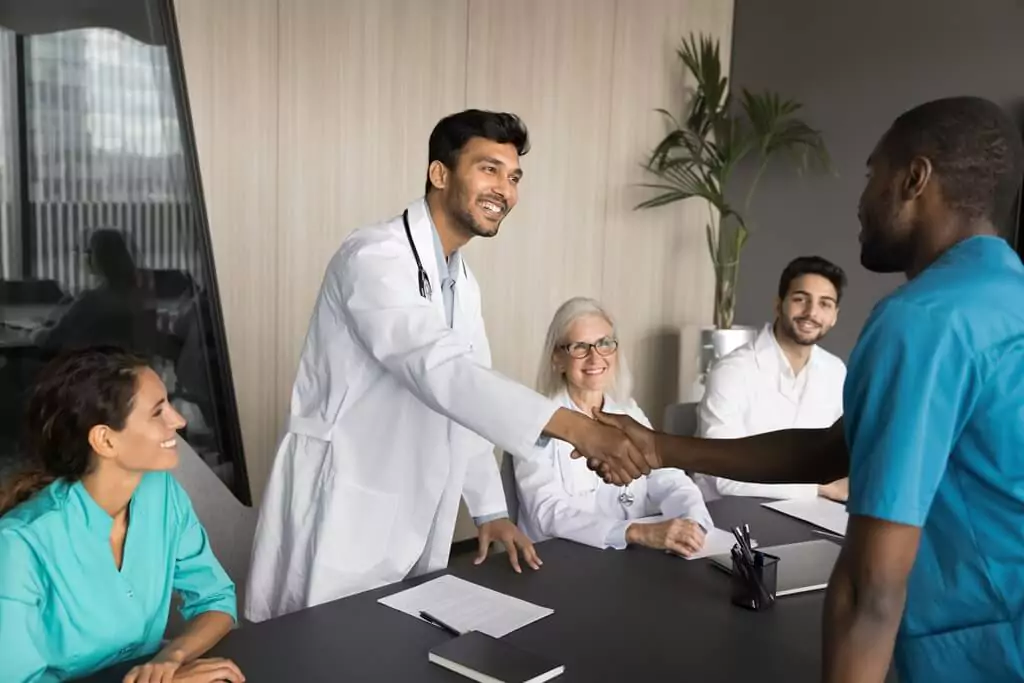 médico apertando a mão de homem em reunião