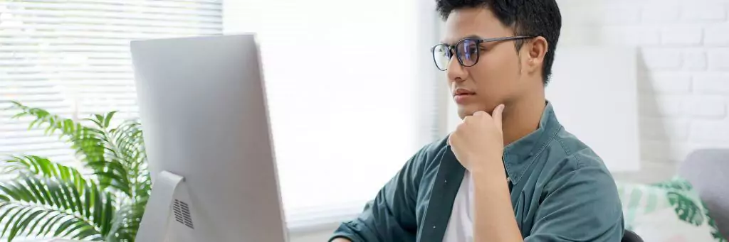 rapaz pensativo olhando para computador