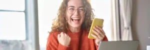 moça comemorando algo em celular