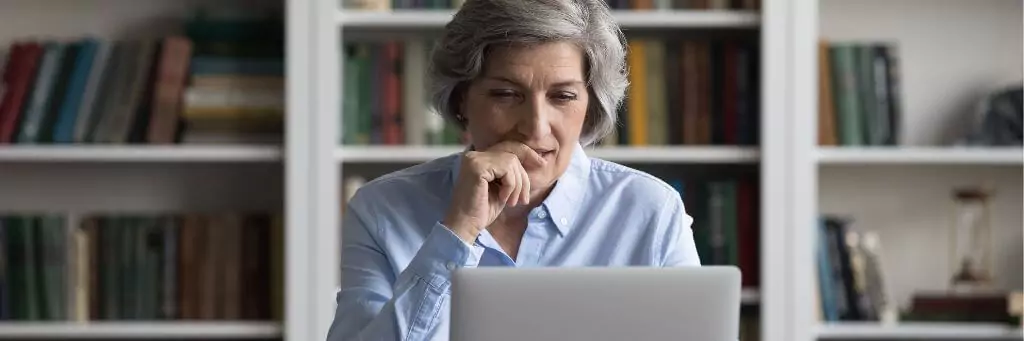 mulher pensativa diante de computador