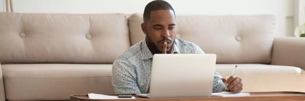 rapaz pensativo com laptop