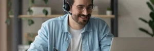 homem sorrindo para algo em computador