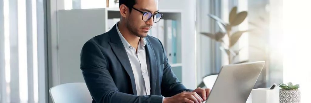 homem digitando em laptop