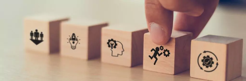 pessoa pegando bloco de madeira com símbolo de homem correndo ao lado de engrenagens