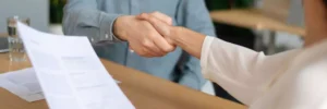 homem e mulher em entrevista dando aperto de mão